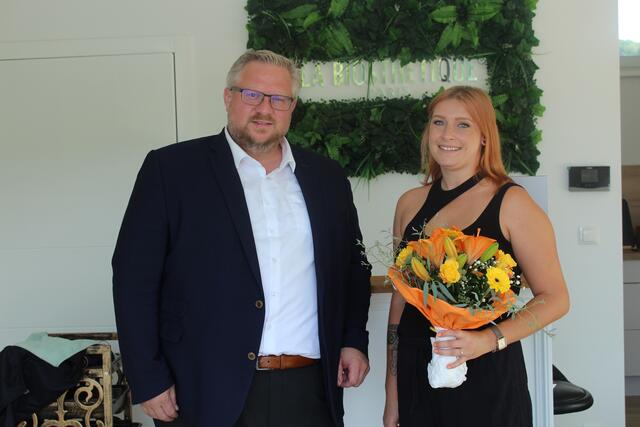 Bürgermeister Michael Göschelbauer überreichte Lisa-Marie Bufler zur Neueröffnung einen Blumenstrauß.  | Foto: Gemeinde