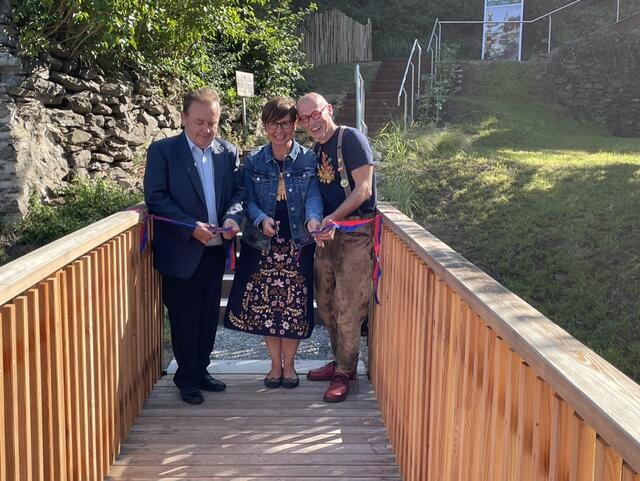 Bürgermeister Landtagsabgeordneter Franz Mold und Edith und Johannes Gutmann (v.l.) durchschneiden das Band und eröffnen die Begehbare Stadtmauer feierlich.  | Foto: Jana Urtz