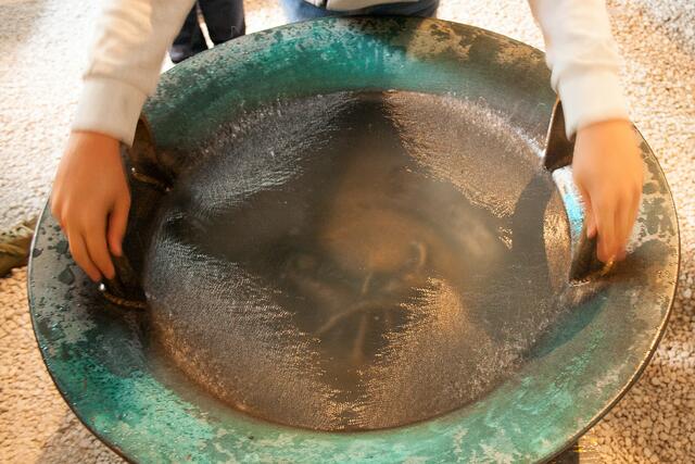 Bild # 8309: Kinder versuchen sich an den Wasserschalen durch reiben an den Griffen. Dadurch können Wasser- Klangbilder entstehen bzw. Vibrationen, welche das Wasser hochspritzen lässt.  | Foto: © by Ing. Günter Kramarcsik