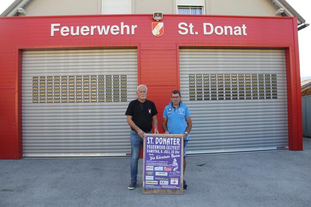 Feuerwehr St. Donat-Kassier Winfried Stuck und Feuerwehr Hörzendorf-Projern-Kassier Reinhard Wernegger, mit dem A 1-Plakat, das die Kärntner Bergwacht veranlasste, gegen die Kameradschaft der Freiwilligen Feuerwehr St. Donat vorzugehen. | Foto: Peter Pugganig