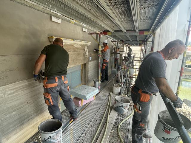 Händisch wird die Fassade am Gebäude von den Arbeitenden aufgebracht. | Foto: Johannes Reiterits