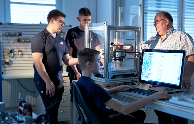 Lehrlingsausbilder Roman Zibusch (r.) und Stellvertreter Benjamin Janicek (l.) mit den Lehrlingen Maximilian Prock und Luca Hirsch an der CNC-Fräse. | Foto: Pollmann