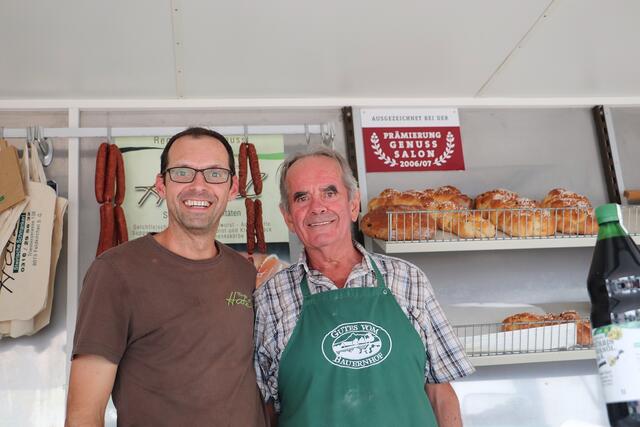 Wie klimafreundliche Mobilität ist der Gemeinde Feldkirchen auch die Regionalität beim Einkaufen ein Anliegen. Daher wurde die neue Broschüre am Bauernmarkt der Öffentlichkeit vorgestellt. Im Bild: Bernhard und Heinz Hatzl mit Lebensmitteln, die auf ihrem Hof in Feldkirchen in Handarbeit hergestellt werden.  | Foto: Edith Ertl