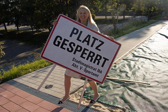 StR Mayr räumt das Schild weg: Der Sportplatz ist zur Benützung freigegeben. | Foto: IKM