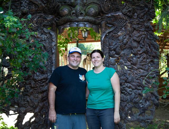Lukas und Birgit Mikulics vor dem Drachentor. Dahinter tut sich das Tiergehege auf, das in einem weitläufigen Garten der wilden Landschaft der Leiser Berge müdet. | Foto: Regina Courtier