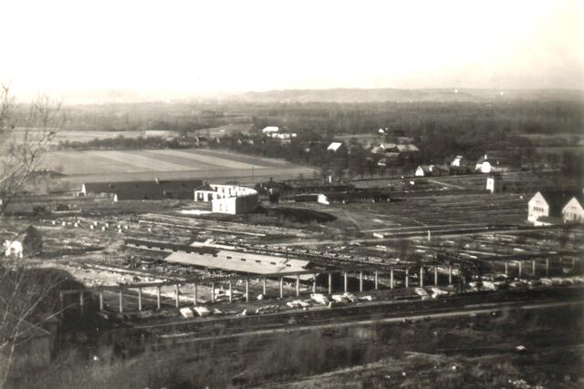 Das großteils niedergebrannte Lager nach dem Krieg: Links im Hintergrund die langgestreckten NS-Baracken, etwa in Bildmitte der Appellplatz. | Foto: Archiv Walzer, Fotorepro Eckhart Herbe