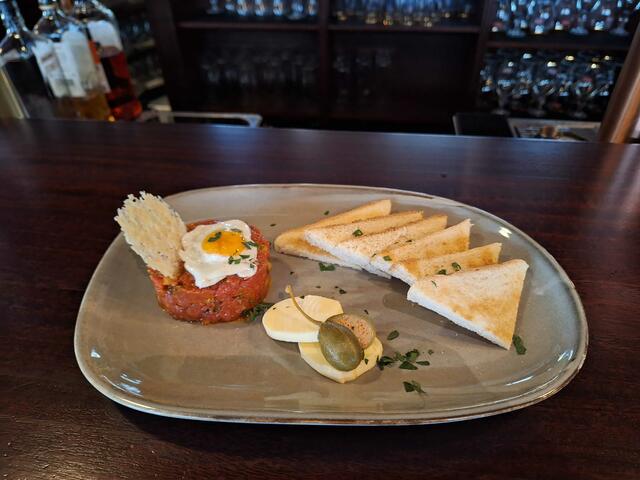 Das Beef Tartare vom Hüftsteak mit einem Wachtelei, Butter und Brot, eignet sich hervorragend als Vorspeise. | Foto: Copyright: Michael Ellenbogen 