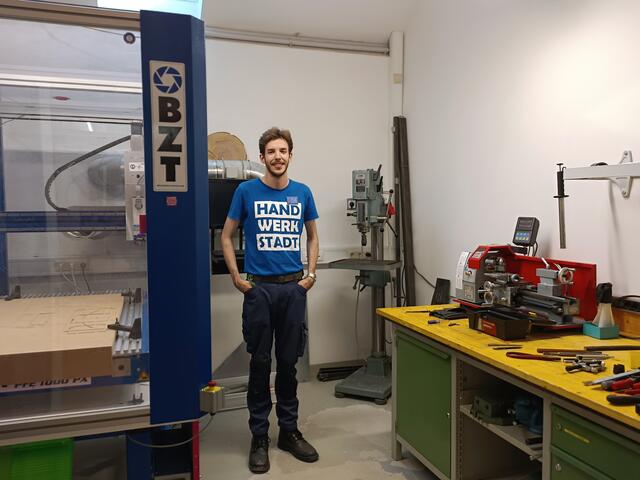 Leonhard mit Opas renovierter Bohrmaschine aus Schweden vor der CNC Fräsmaschine 