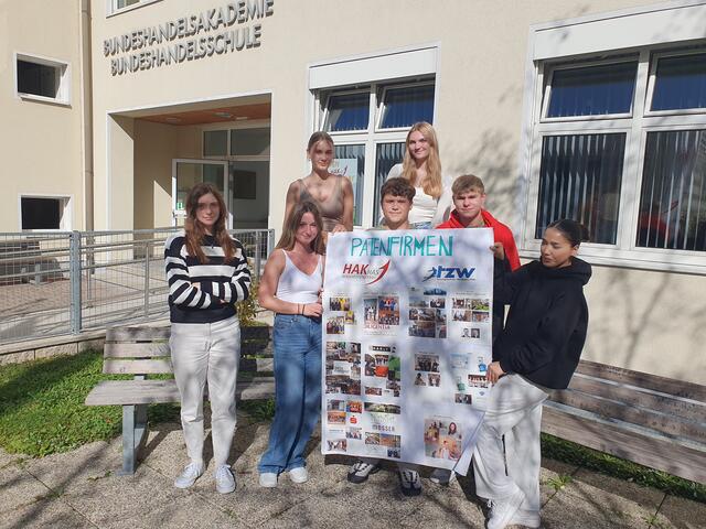 Die Business-Schülerinnen und -schüler der 2AK präsentieren voller Stolz ihre Fotocollage zu den Patenfirmen von HAK und TZW: v.l.n.r. Laura Schmid, Emilia Heim, Chiara Kirchleitner, Jannik Ritt, Carina Halsmayr, Franz Zahnt, Farsane Mohammadi | Foto: HAK