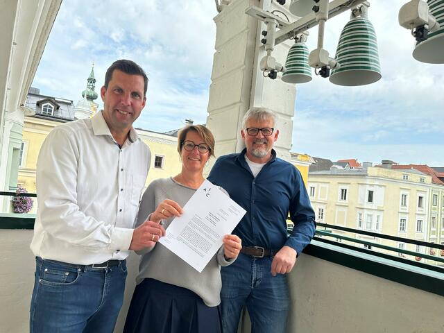 Diesen Brief aus Genf darf man zurecht an die große Glocke hängen: Bürgermeister Stefan Krapf, Keramik-Koordinatorin Eva Fürtbauer und Kulturreferent Andreas Hecht unterm Gmundner Keramik-Glockenspiel. | Foto: Stadtgemeinde Gmunden