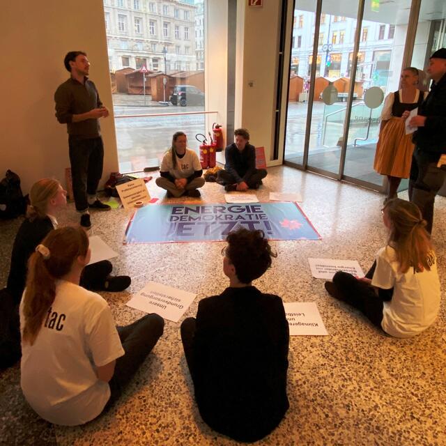 Die Aktivistinnen und Aktivisten diskutieren im Foyer in der Zentrale mit Verbund-Mitarbeitern über Energiethemen und die aktuellen Preise. | Foto: Attac Austria/Flickr
