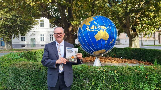 Franz Michael Zagler vor der Salzburger Weltkugel und dem neuen Magazin von Erwachet! (Foto AZ)
