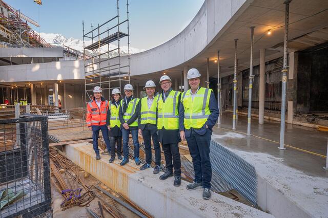 Bauteils B im Hintergrund des Bildes ist im Rohbau fertiggestellt, bietet im Erdgeschoss Flächen für Handel und Genuss sowie im Dach- und ersten Obergeschoss ein Terrassenrestaurant, es freuen sich - von links: Markus Pfeifer (STRABAG Technischer Direktionsleiter Tirol &amp; Vorarlberg) Sabine Haselwanter (Technische Projektleiterin DAS RAIQA), Christoph Pichler (Pichler &amp; Traupmann Architekten), Christof Splechtna (Vorstandsmitglied RLB Tirol), Reinhard Mayr (Vorstandsvorsitzender RLB Tirol) und Thomas Wass (stv. Vorstandsvorsitzender RLB Tirol) | Foto: RLB/Franz Oss