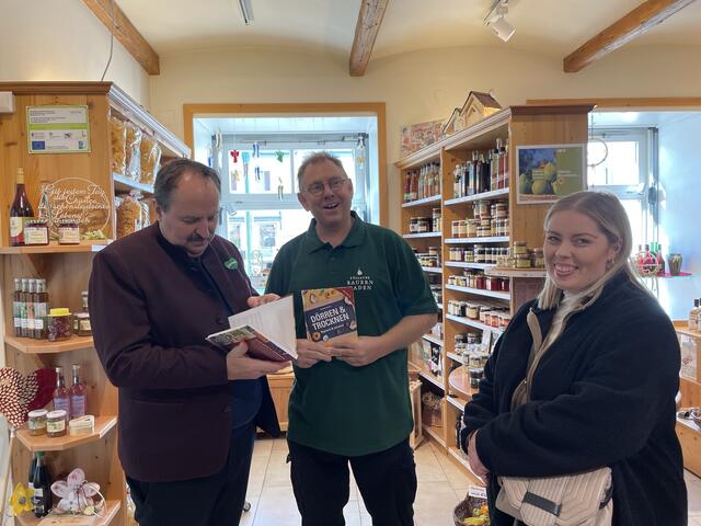 Wolfgang Zemanek (Mitte) ist selbst Buchautor. Beim Besuch von Johann Lafer in Pöllau bekam er ein Exemplar von Zemaneks Buch über "Dörren und Trocknen" überreicht.  | Foto: Olga Seus