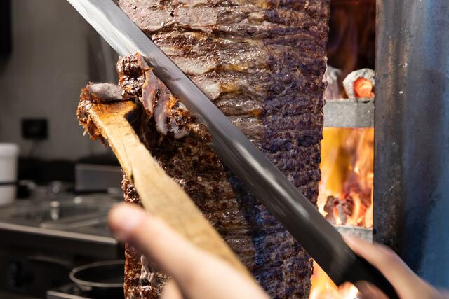90 Kilo Rindfleisch werden auf einen Spieß per Hand gesteckt und über dem Holzkohlegrill gegrillt. | Foto: Robin Consult/Fellner