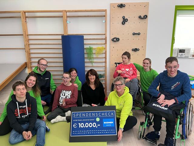 Sandra Bodner (Bodner Gruppe, in der Mitte) und Susanne Schöllenberger-Baumgartner, Obfrau des Vereins „Schritt für Schritt“ (rechts) mit Jugendlichen und Mitarbeitern bei der Spendenscheckübergabe kurz vor Weihnachten. | Foto: BODNER Gruppe