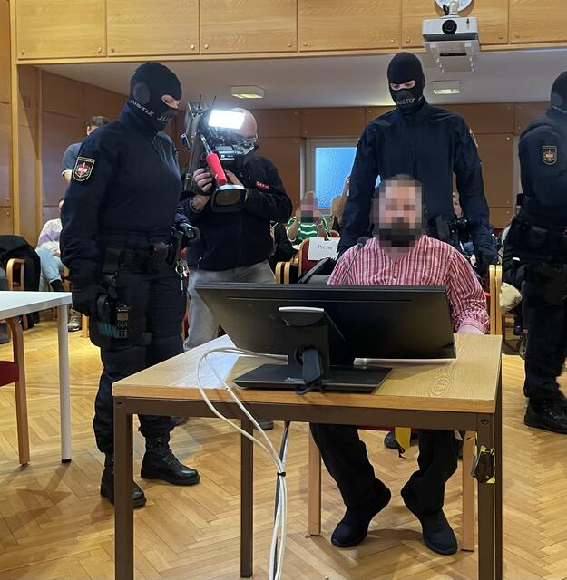 Vermummte Justizwachebeamten bewachen den Mann beim Prozess, einer ist jederzeit bereit einen Taser zu ziehen. | Foto: BRS