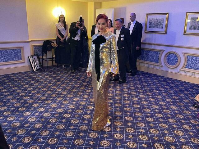 Priscilla Presley trägt ein gold-schwarzes Kleid von  Designerin Nina Ricci. | Foto: Patricia Hillinger/RMW