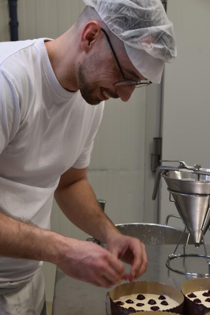 Die Kirschen werden per Hand in jeden einzelnen Cheezecake gelegt. | Foto: Geiger