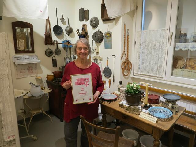 In der alten Schauküche mit Gegenständen von 1880 bis 1940 nimmt Doris Weis die Urkunde zur Heldin von Währing entgegen. | Foto: Sabine Krammer