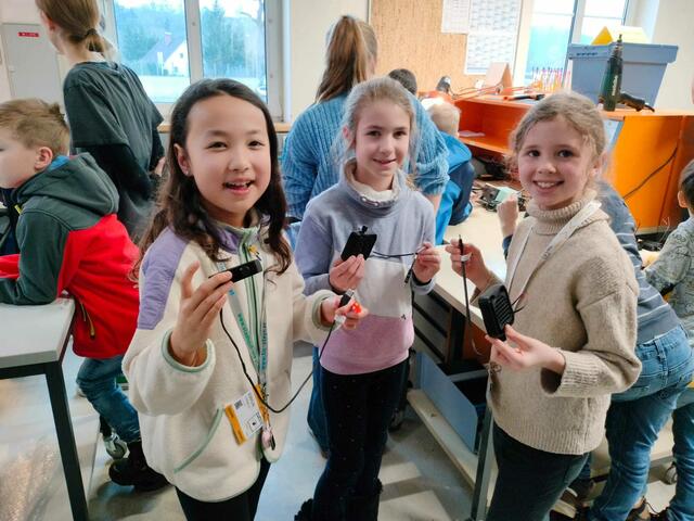 Begeistert präsentieren die Mädchen, die Ventilatoren, deren Kabel sie angelötet haben, während andere im Hintergrund noch am Werken sind.  | Foto: Claudia Steinbach I CoderDojo Steyr
