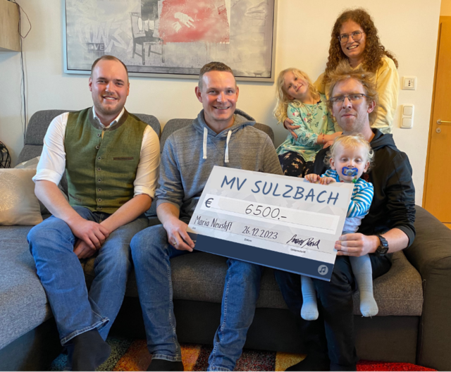 Alexander Großalber (Obmann-Stv.), Daniel Gmainer (Obmann) und Elisabeth Großeiber übergeben den Reinerlös vom Benefizkonzert an Familie Hauser.