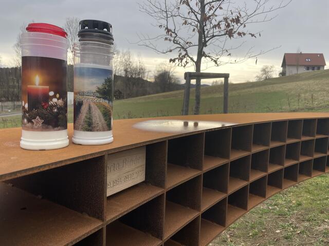 Gravierte Holzblöcke in einem Fächersystem bieten Platz für Kerzen und dienen als sichtbare Erinnerung.
