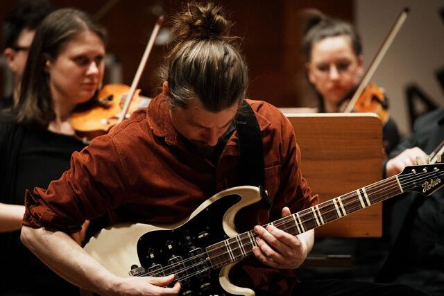 Begeisterte zuletzt mit einem aufbäumend-rockigen E-Gitarren-Solo: Philipp Ossanna bei der Uraufführung seines Werks "State of Matter für E-Gitarre, Electronics und Kammerorchester". | Foto: Amir Kaufmann