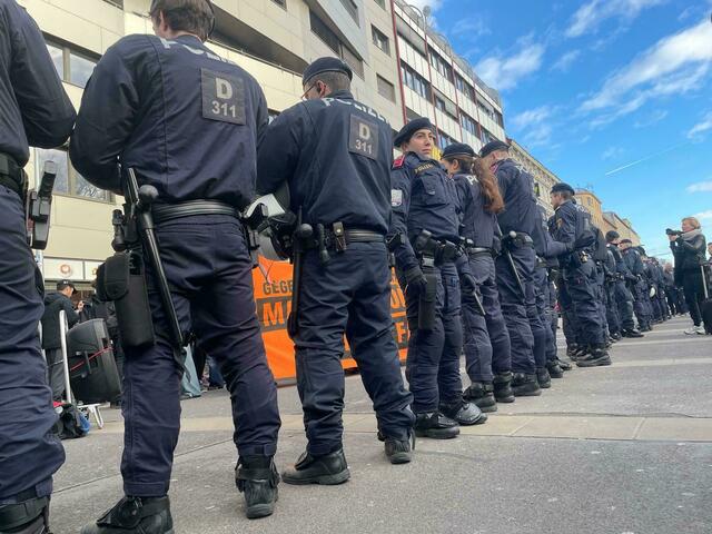 Die Polizei ist mit Großaufgebot im Einsatz, gegen 16.10 Uhr formierte man eine menschliche Mauer, um die zwei Seiten örtlich zu trennen.  | Foto: Barbara Schuster/RMW