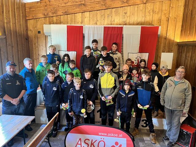 Die Bezirkscup Geehrten 2024 mit den Offiziellen;
vl. Gemeinderat Beihammer, Rupert Straßer; hinten auf dem Stockerl Rang 2 EC Oberndorf, Rang 1 ESV Gasteig, Rang 3 EC Brixen, vorne Rang 5 EC Rummlerhof, Rang 4 Spg. Erpfendorf / Gasteig und Bezirksobmann Andi Aberger