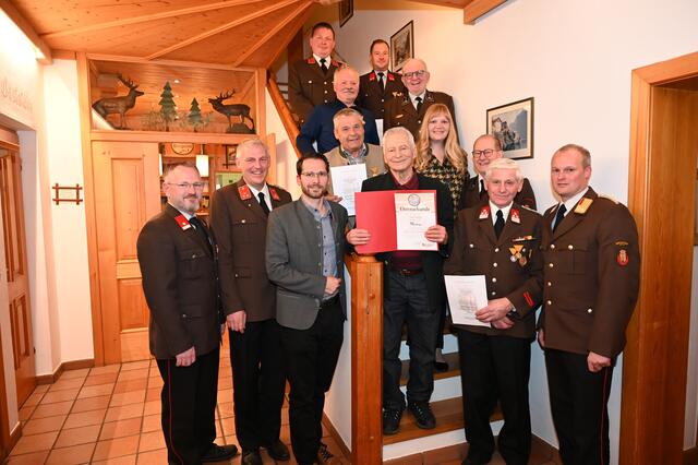 Die geehrten mit den Ehrengästen, allen voran Karl Höller (rote Mappe) für 70 Jahre Feuerwehrzugehörigkeit
