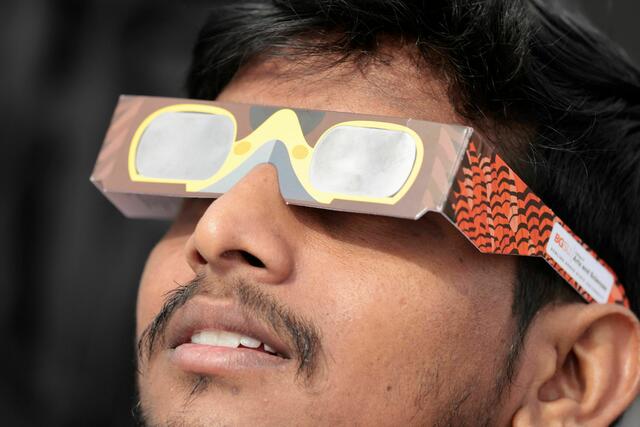 Ein Zuschauer betrachtet die Sonnenfinsternis durch eine Schutzbrille auf dem Football-Feld der Bowling Green State University am 8. April 2024 in Bowling Green, Ohio. | Foto: JEFF KOWALSKY / AFP / picturedesk.com 