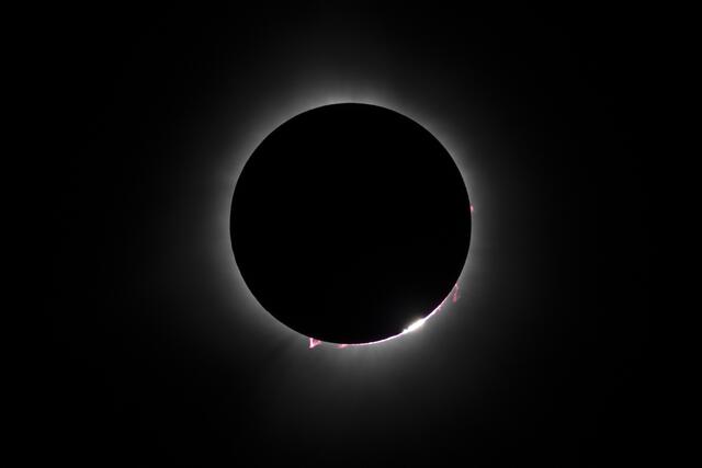 Rote Protuberanzen lösen sich von der Sonne, als der Mond während einer totalen Sonnenfinsternis über Nordamerika in Magog, Quebec, Kanada, am 8. April 2024 vor der Sonne vorbeizieht. | Foto: STAN HONDA / AFP / picturedesk.com