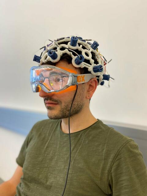 Alessandro Venturino mit einem frühen Prototyp. Der Neurowissenschafter zeigt die Anwendung des brillenähnlichen Geräts von Syntropic Medical | Foto: Syntropic Medical GmbH