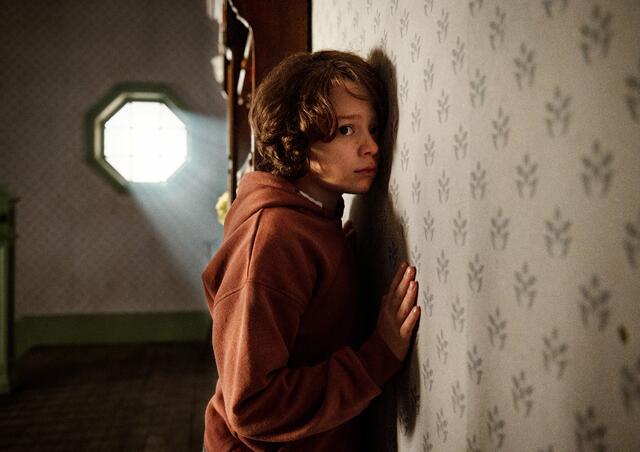 Der achtjährige Peter (Woody Norman) wird jede Nacht von einem unheimlichen Klopfen hinter den Wänden seines Zimmers aus dem Schlaf gerissen. | Foto: TOBIS Film GmbH.