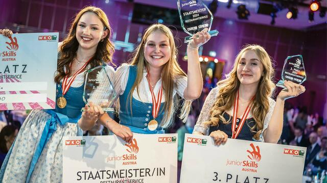 Das Team Salzburg holte sich bei den „JuniorSkills 2024“ in Klagenfurt den Gesamtsieg in der Bundesländerwertung sowie eine Gold- und eine Silbermedaille in Restaurant-Service. Im Bild: Staatsmeisterin Emily Langegger (Mitte) und Vizestaatsmeisterin Daria Gelic (links) bei der Siegerehrung.  | Foto: WKO/bild[ART]isten