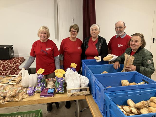 Ein Teil des ehrenamtlichen Caritas-Teams vor den gefüllten Tischen | Foto: Stockmann