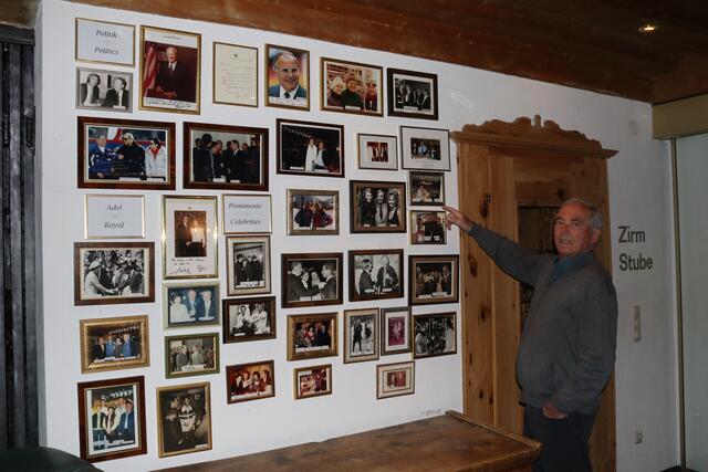 Karl Schranz zeigt auf die Bilderwand in seinem gleichnamigen Hotel. 