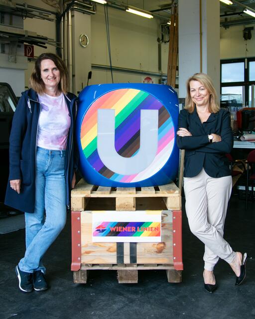 Petra Hums, Geschäftsführerin für den kaufmännischen Bereich, und Alexandra Reinagl, Vorsitzende der Geschäftsführung, mit dem U-Bahn-Würfel in Regenbogen-Progressiv-Farben | Foto: Wiener Linien / Julia Allerding