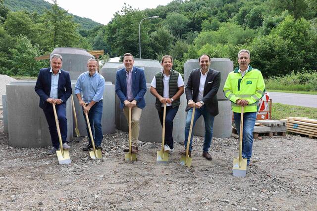 Krzysztof Pyrek, Leiter der Abwasserentsorgung, Stadtrat Christoph Stattin, Bürgermeister Christoph Kaufmann, Baudirektor Peter Neubauer, Michael Kiener von Ziviltechniker Kiener, Bauaufsicht, und Mario Maier von der ausführenden Baufirma Pittel und Brausewetter, setzen die Spaten an – im Hintergrund warten die Kanalschächte auf ihren Einsatz.
 | Foto: Stadtgemeinde Klosterneuburg / Lutz