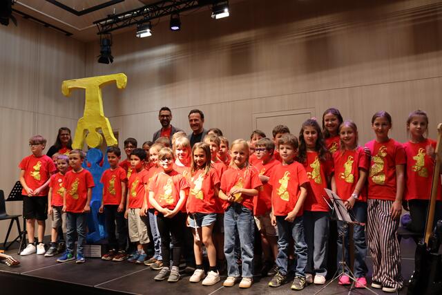 Die Kinder der VS Pettneu mit ihrem Direktoren Emanuel Mathies und Bgm. Patrik Wolf - links ist das Kunstwerk zu sehen, das die Volksschüler:innen der Gemeinde schenkten.  | Foto: Elisabeth Zangerl