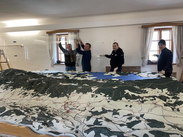 Fleißige Hände stellten das Böhmerwald-Relief, das Josef Bayr (2. v. l.) gebaut hat, im Heimathaus auf.  | Foto: Karin Bayr