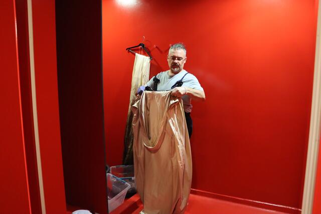 Giuseppe Palella bemalt noch die letzten Umhänge und Kostüme für die Aufführung von "Aida" in der Oper im Steinbruch in Sankt Margarethen. Dabei befindet er sich in den Duschen der Tänzerinnen und Tänzer, während diese Probe haben, um schließlich ordentlich putzen zu können.  | Foto: RMA Triebaumer