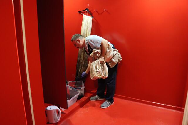 Giuseppe Palella bemalt noch die letzten Umhänge und Kostüme für die Aufführung von "Aida" in der Oper im Steinbruch in Sankt Margarethen. Dabei befindet er sich in den Duschen der Tänzerinnen und Tänzer, während diese Probe haben, um schließlich ordentlich putzen zu können.  | Foto: RMA Triebaumer