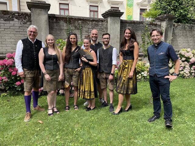 Kiwanis Club Villach-Präsident Rene Tarmastin (links), Alexander Weiss, Juniorchef von Trachten Isola (5. von links) und Stadtpfarrer Richard Pirker (rechts) mit den Isola-Models, die die neue Villacher Tracht präsentieren. Mit dabei: "Pasta Mama" Daniela Pfleger (3. von links). | Foto: MeinBezirk.at