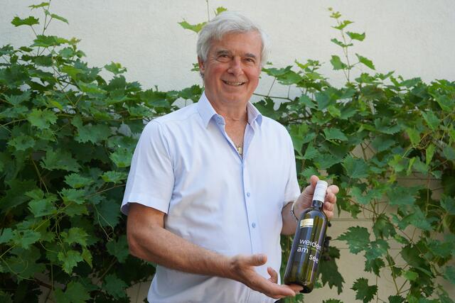 Heinrich Hareter mit dem Gemeindewein 2024 der Winzerfamilie Guttmann | Foto: Andrea Glatzer