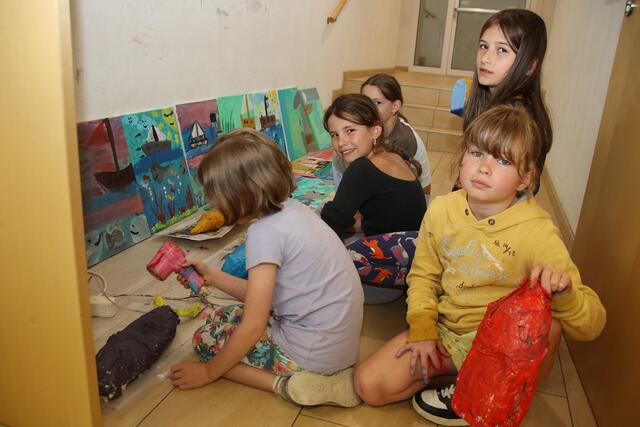 Gemeinsam trocknen die Kinder ihre frisch entstandenen Malereien.