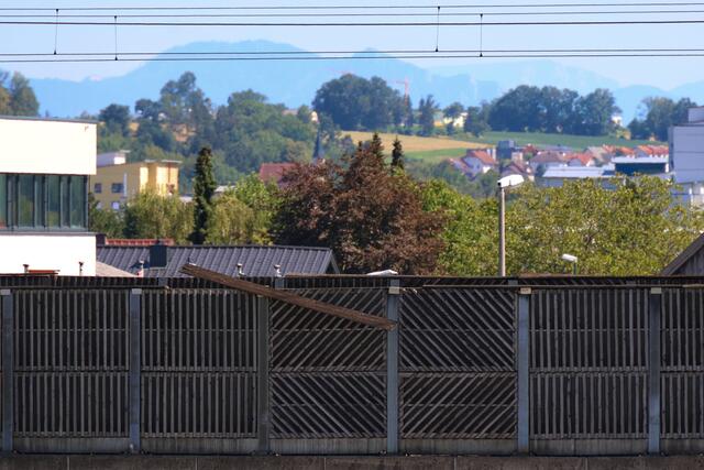 Starke Verwitterung an Lärmschutzwand einer Eisenbahnbrücke in Wels-Vogelweide: Die Feuerwehr konnte die lose gewordene Latte sicher entfernen.