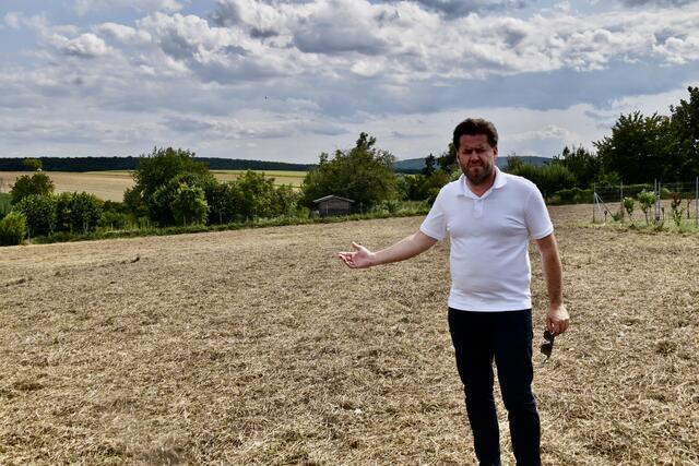 Bgm. Bernhard Herics weist auf das Grundstück hin, wo das begehbare Hügelgrab entstehen soll. | Foto: Michael Strini