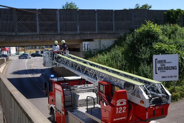 Starke Verwitterung an Lärmschutzwand einer Eisenbahnbrücke in Wels-Vogelweide: Die Feuerwehr konnte die lose gewordene Latte sicher entfernen.